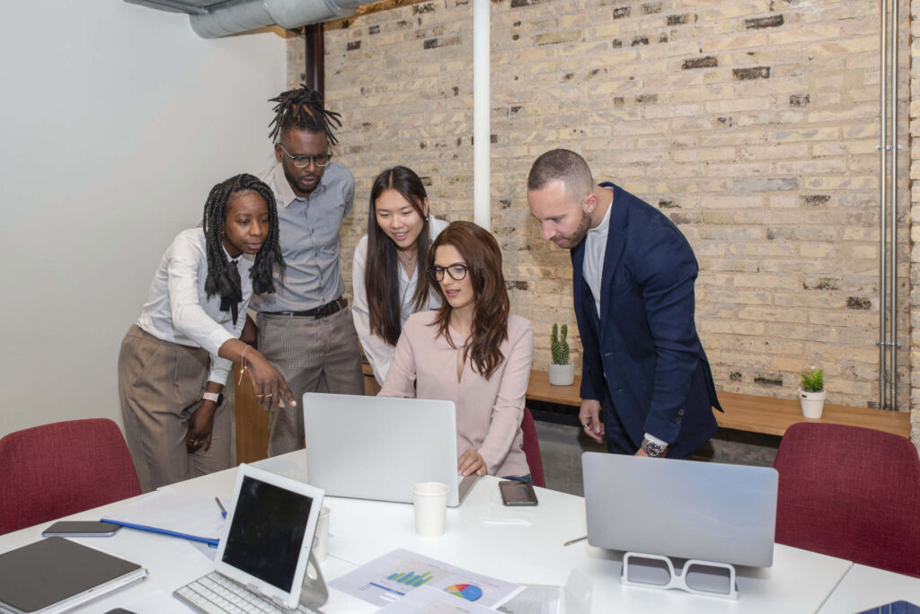 a young entrepreneur sitting in the boardroom with multiethnic coworkers around her discussing new ideas and strategies of their project, cooperation concept